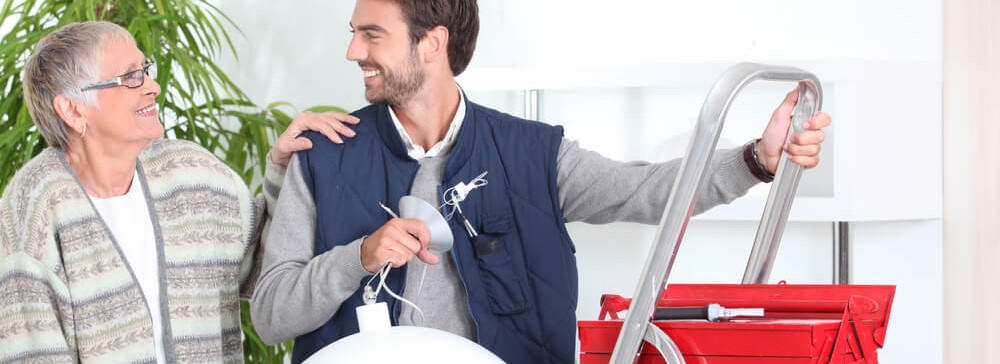 Nasmejan mladenic pomaga starejsi gospe obesiti lestenec